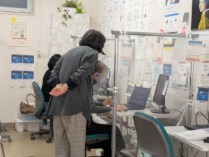 市民パソコン塾の教室でインストラクターが受講生をサポートしている様子
